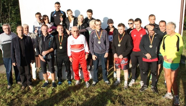 Pamiątkowe zdjęcie biegaczy uczestniczących w Crossie Piekielnica w Bukowej. W dolnym rzędzie w biało-czerwonym stroju główny organizator Włodzimierz Zawalski.