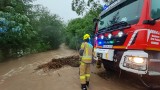 Burze w Gorlickiem. Woda zalewa jedną z posesji w Bielance. Na miejscu strażacy układają mur z worków z piaskiem