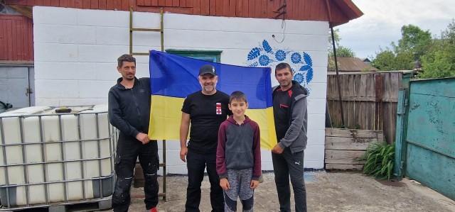 Uczestnicy akcji pomocowej, od lewek Krystian Wolny, Krzysztof Adamski, oraz Ukrainiec z synem