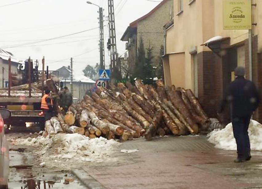 Wypadek w Rudach. Bale drewna spadły na ulice i chodnik....