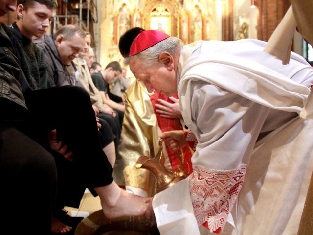 Arcybiskup Edward Ozorowski w trakcie obrzędu obmycia nóg