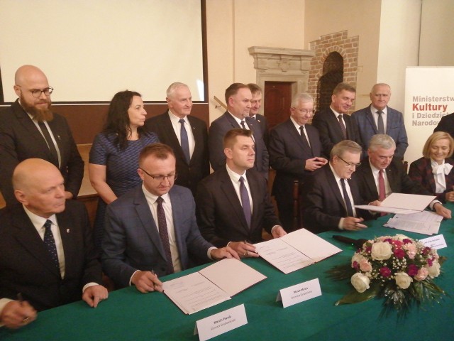 Od lewej: wicestarosta Wojciech Dzieciuch, starosta Marcin Piwnik, burmistrz Marcin Marzec, minister Piotr Gliński, Andrzej Bętkowski, marszałek województwa i Renata Janik, wicemarszałek województwa podpisują umowę.