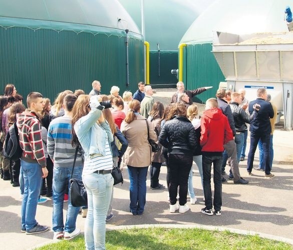 Arkadiusz Witowski (w głębi z wyciągniętą ręką) pokazuje gościom z Białogardu silosy biogazowni w Grzmiącej