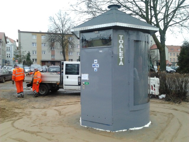 Ekipa montażowa kończy instalację szaletu na parkingu za ratuszem.