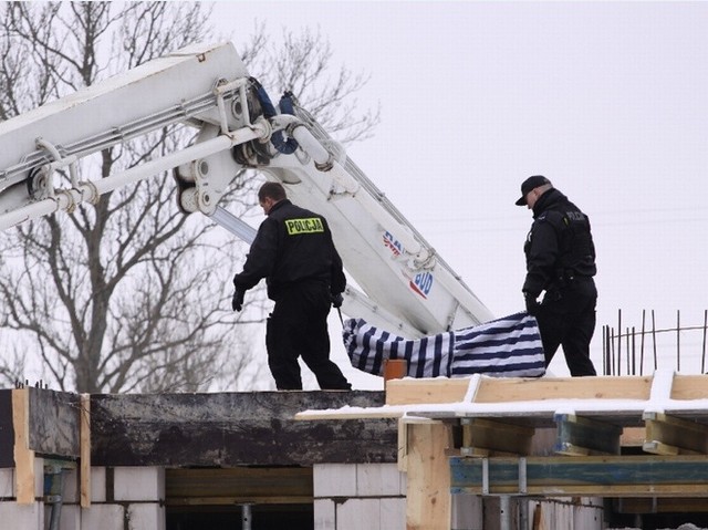 Policjanci wynoszą ciało robotnika. Do zdarzenia doszło 13 lutego 2010 roku.
