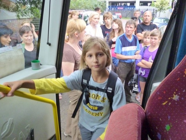 Wiktoria wsiada do autobusu, którym pierwsza grupa dzieci pojechała na kolonie do Augustowa.