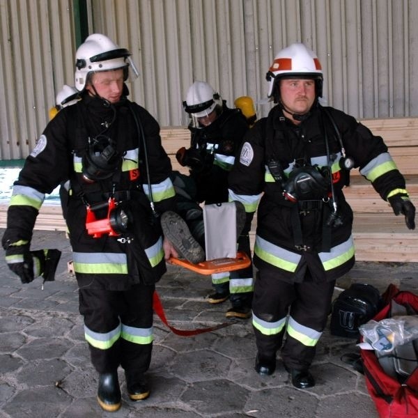 Ratownicy wynoszą poszkodowane pracownika jednej z firm kooperujących z hutą szkła w Sandomierzu.