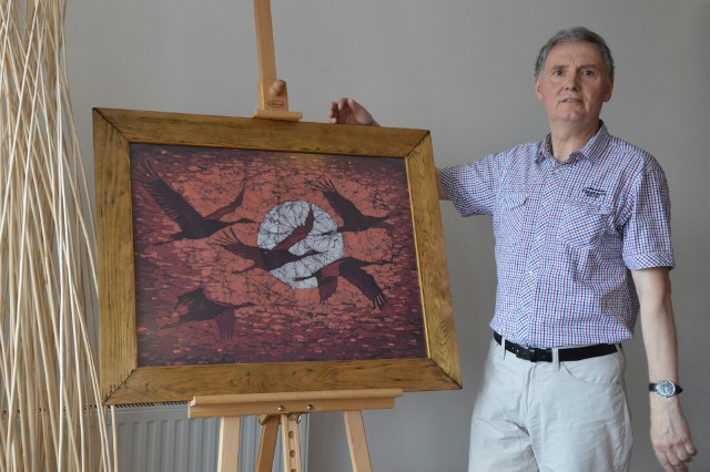 Roman Szyszka ze swoim obrazem, który jest jednym z eksponowanych na wystawie w kawiarni „Widokowa”.