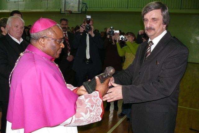 Henryk Frynas, dyrektor II LO w Starachowicach wręcza czarnoskóremu arcybiskupowi Emery Kabongo okolicznościową statuetkę szkoły.