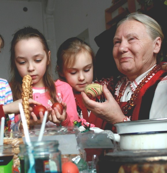 Stanisława Królik na lekcji tradycji uczy dzieci z przedszkola w Nowogrodzie malowania pisanek kurpiowskich