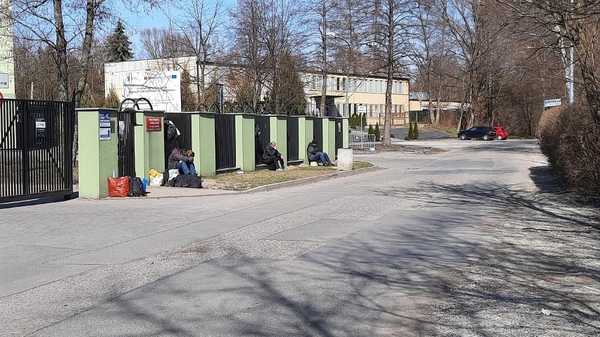 Kraków. Bezdomni koczują ma murku przed ogrzewalnią, żeby zająć sobie miejsce na nocleg  