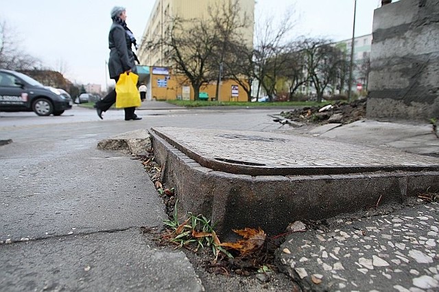 Klapa od studzienki telekomunikacji sterczy nad chodnikiem w ulicy Legnickiej, stwarzając zagrożenie dla pieszych.