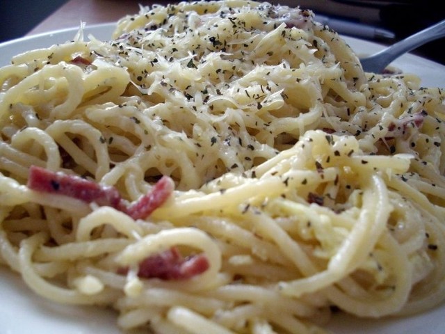 Przełożone na talerze spaghetti posypujemy startym parmezanem.