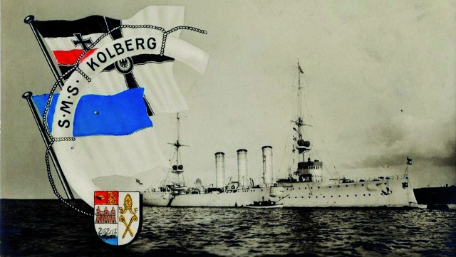 Lekki krążownik SMS „Kolberg” uwieczniony na pocztówce z epoki. Z lewej strony widoczna badnera cesarskiej marynarki wojennej oraz flaga i herb miasta