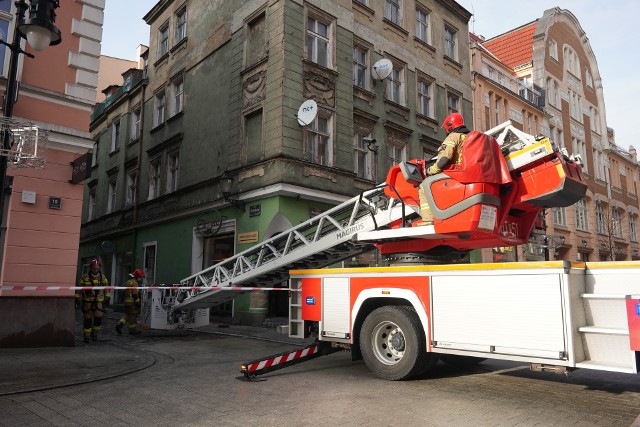 Strażacy ostali zaalarmowani, że z kamienicy spadają cegły z gzymsu.