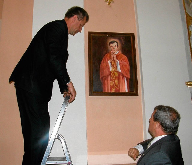 Obraz zawieszają (od lewej) Marek Pycia i Czesław Gamrat