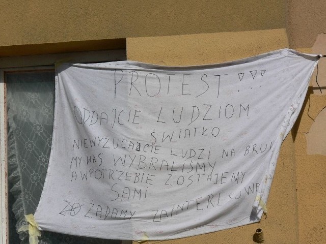 Mieszkańcy zawiesili na budynku płachtę, na której napisali swoje żądania.