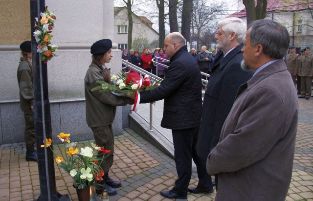 Władze powiatu niżańskiego ze starostą Robertem Bednarzem składają kwiaty pod Tablicą Katyńską.