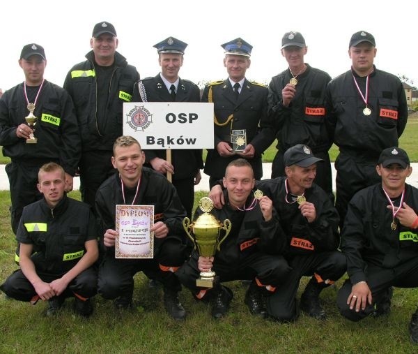 Drużyna OSP z Bąkowa. Stoją od lewej: Jacek Popecki, Grzegorz Staliński, Jerzy Pająk, Jarosław Bryła, Krzysztof Krawczyk, Adam Stadnik. Na dole od lewej: Patryk Luty, Daniel Michta, Tobiasz Wróbel, Grzegorz Jaros, Janusz Dyśko.