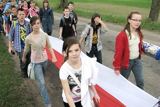 Dzieci i młodzież z Książek z flagą maszerowali ze szkoły do pomnika w Brudzawkach, gdzie w piątek odbyły się uroczystości upamiętniające oficerów zamordowanych w Katyniu