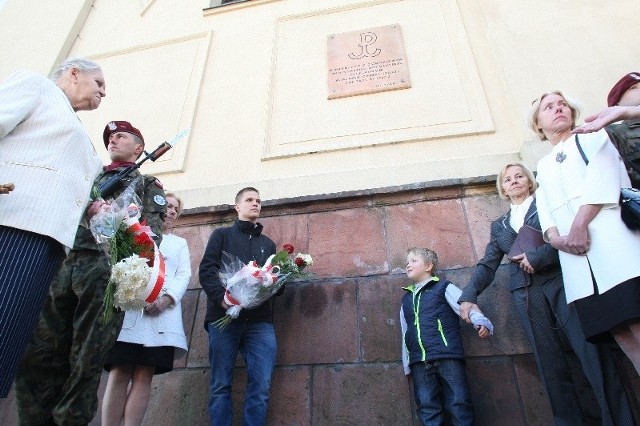 W ścianie dzwonnicy katedralnej odsłonięto tablicę w miejscu, gdzie kieleccy harcerze namalowali znak Polski Walczącej podczas II Wojny Światowej. W uroczystości brały udział rodziny, córki Wiesława Sadkowskiego, Joanna i Marta ( w białych żakietach), siostra Wojciecha Gołąbka  Ewa Ludwinek ( pierwsza z lewej) i jego żona Danuta ( z prawej przy pomniku) oraz wnuki Filip ( z kwiatami) i Jakub Grdeniowie.