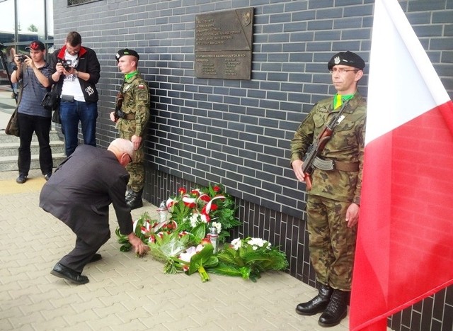 Eugeniusz Lis składa kwiaty pod tablicą pamiątkową na dworcu w Lesznie
