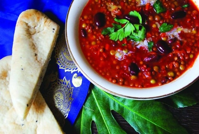 Dhal, czyli indyjską zupę z soczewicy podajemy ozdobioną świeżą natką kolendry i wiórkami masła.