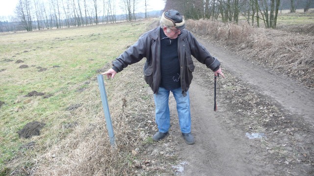 Zdzisław Mastalarczyk pokazuje, gdzie według niego wkopano w drogę kamień graniczny