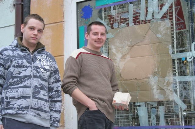 Maciej Lachnerowicz (z lewej) i Sebastian Śmigowski pokazują, jaką cegłą wandale wybili szybę wystawową w sklepie Familia Elektronarzędzia na starówce. Znaleźli ją wewnątrz sklepu.