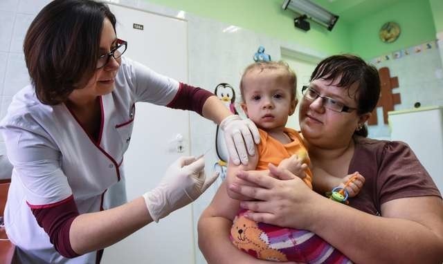 Magdalena Zajączkowska, mama 13-miesięcznej Gai, stosuje się do zaleceń lekarzy. Na zdjęciu szczepienie wykonuje pielęgniarka Beata Sumara z przychodni Gryf-Med na Kapuściskach