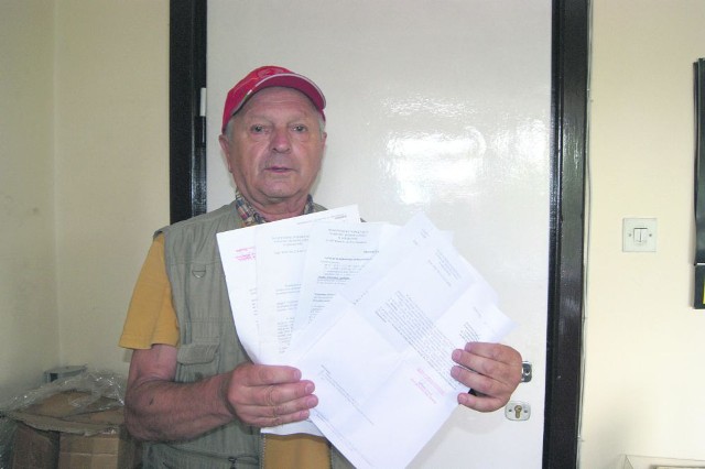 Emil Kotarba pokazuje stos listów, jakie przez lata wysyła do wszelkich możliwych instytucji