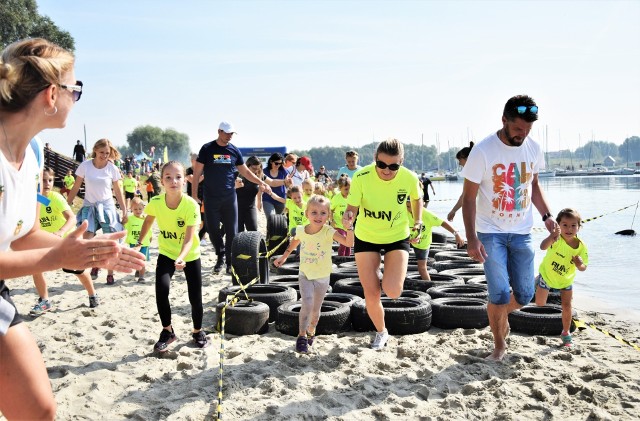 Około 150 dzieci wystartowało w Run Fit Kids, czyli biegu z przeszkodami dla dzieci nad jeziorem w Tarnobrzegu. Sportową imprezę zorganizowało w sobotę stowarzyszenie Fitneska. Na blisko kilometrowym dystansie młodzi zawodnicy pokonali wiele przeszkód, atrakcją była wodna ślizgawka. Rozegrano biegi dla przedszkolaków, dzieci z klas 1-3, 4-6 i 7-8. Najmłodszym towarzyszyli rodzice, z których wielu później pokonało trudną trasę Run Fit dla dorosłych. Zobaczcie!Ekstremalny bieg Run Fit Elite nad jeziorem w Tarnobrzegu