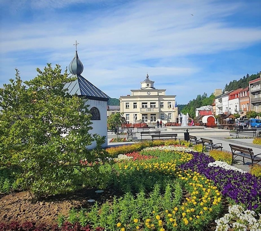 Muszyński rynek pełen kwiatów i zieleni. Ratusz w stylu...