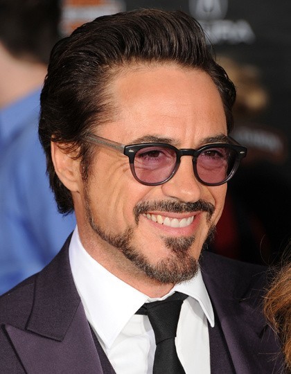 Robert Downey Jr nosi trzyrzędowy garnitur i czarny krawat....