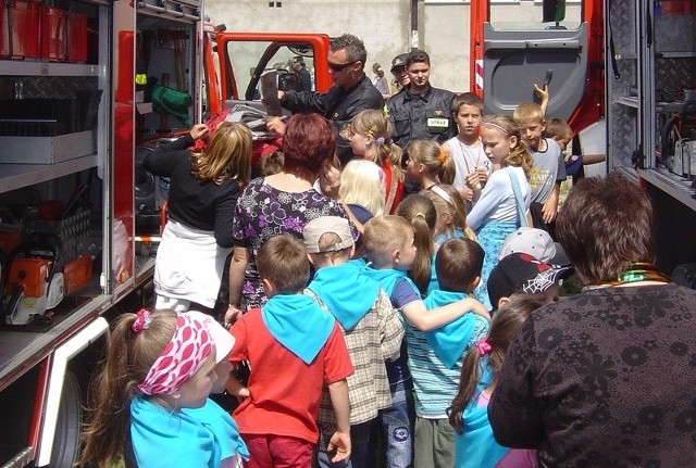 Dzieci z wielkim zaciekawieniem oglądają sprzęt strażacki. Na zdjęciu o swojej pracy opowiadają doświadczeni ogniowcy Przemysław Kowalski i Władysław Jasiński.