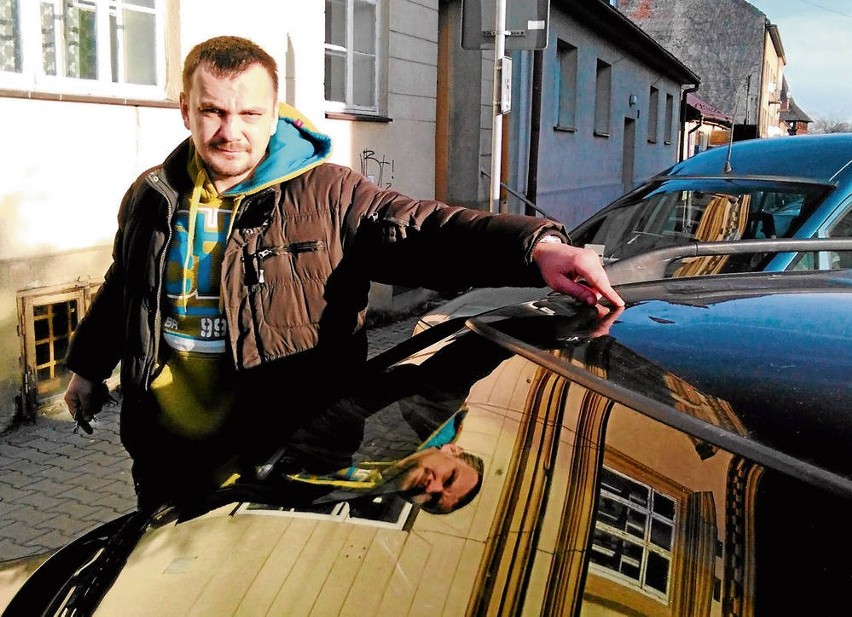 Dominik Olszewski pokazuje wgniecenie dachu swego samochodu