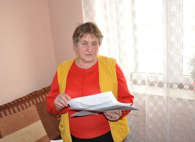 Pani Wiesława Grzesiak pokazuje dokumenty.