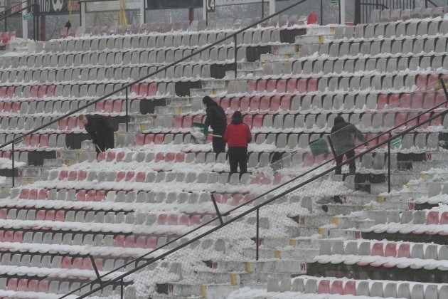 Kibice Widzewa podczas odśnieżania stadionu.