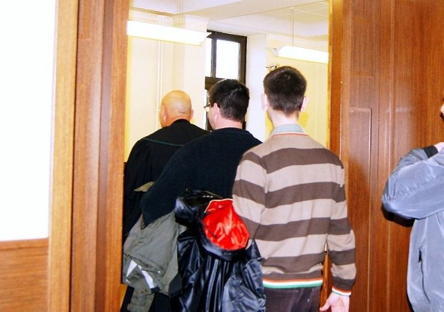 Oskarżeni policjanci Kazimierz T. i Wojciech P. wchodzą na salę sądową w towarzystwie obrońców