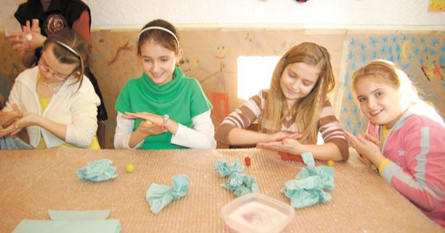 Dzieci na zajęciach robią pirackie kolczyki z filcu. 