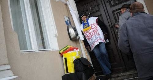 Jerzy Rosiński postanowił zaostrzyć protest i przykuł się łańcuchem do drzwi ratusza