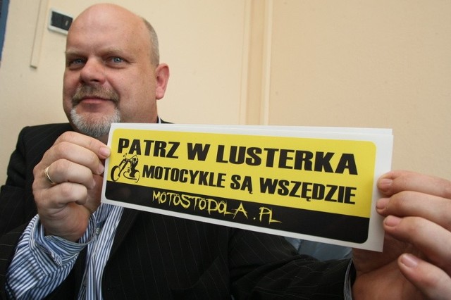 Naklejkę, jaką można dostać od stowarzyszenia motorowego Motostodola.pl prezentuje jego przedstawiciel, Marek Olczak.