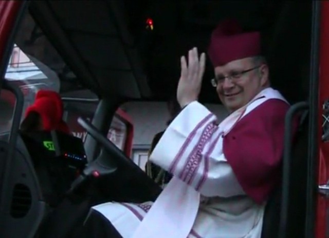 Biskup Andrzej Czaja jako kierowca wozu strażackiego.