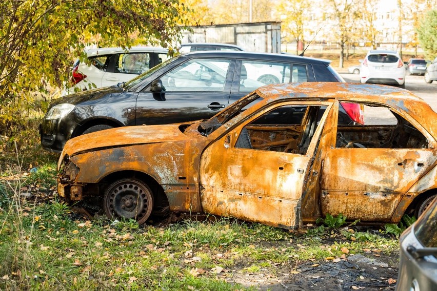 Spalony wrak samochodu stoi na parkingu na Wzgórzu Wolności...