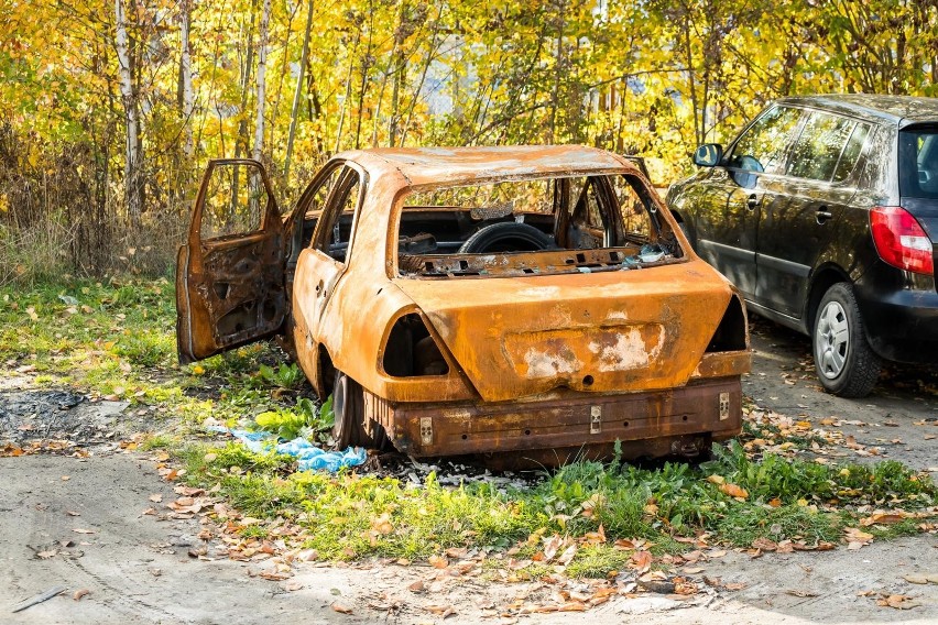 Spalony wrak samochodu stoi na parkingu na Wzgórzu Wolności...