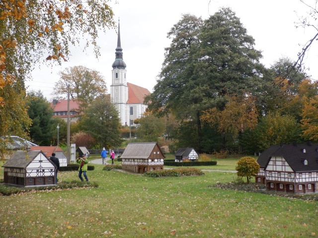 Park miniaturowych domów łużyckich w Cunewalde (na pierwszym planie) i największy kościół wiejski w Niemczech