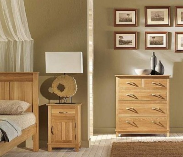 Sypialnia w stylu eko, a w niej lampa z wykorzystanym fragmentem pnia.