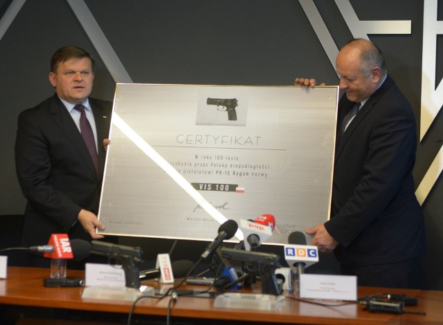Wiceminister obrony Wojciech Skurkiewicz (z lewej) i prezes „Łucznika” Adam Suliga prezentują certyfikat o nadaniu nazwy pistoletowi.