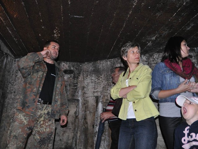 Piotr Letki(w moro) oprowadza turystów po szczecineckim bunkrze.