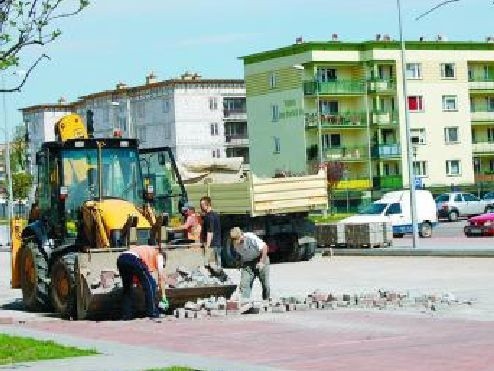 Robotnicy usuwają popękaną kostkę, a na jej miejsce układają nową.